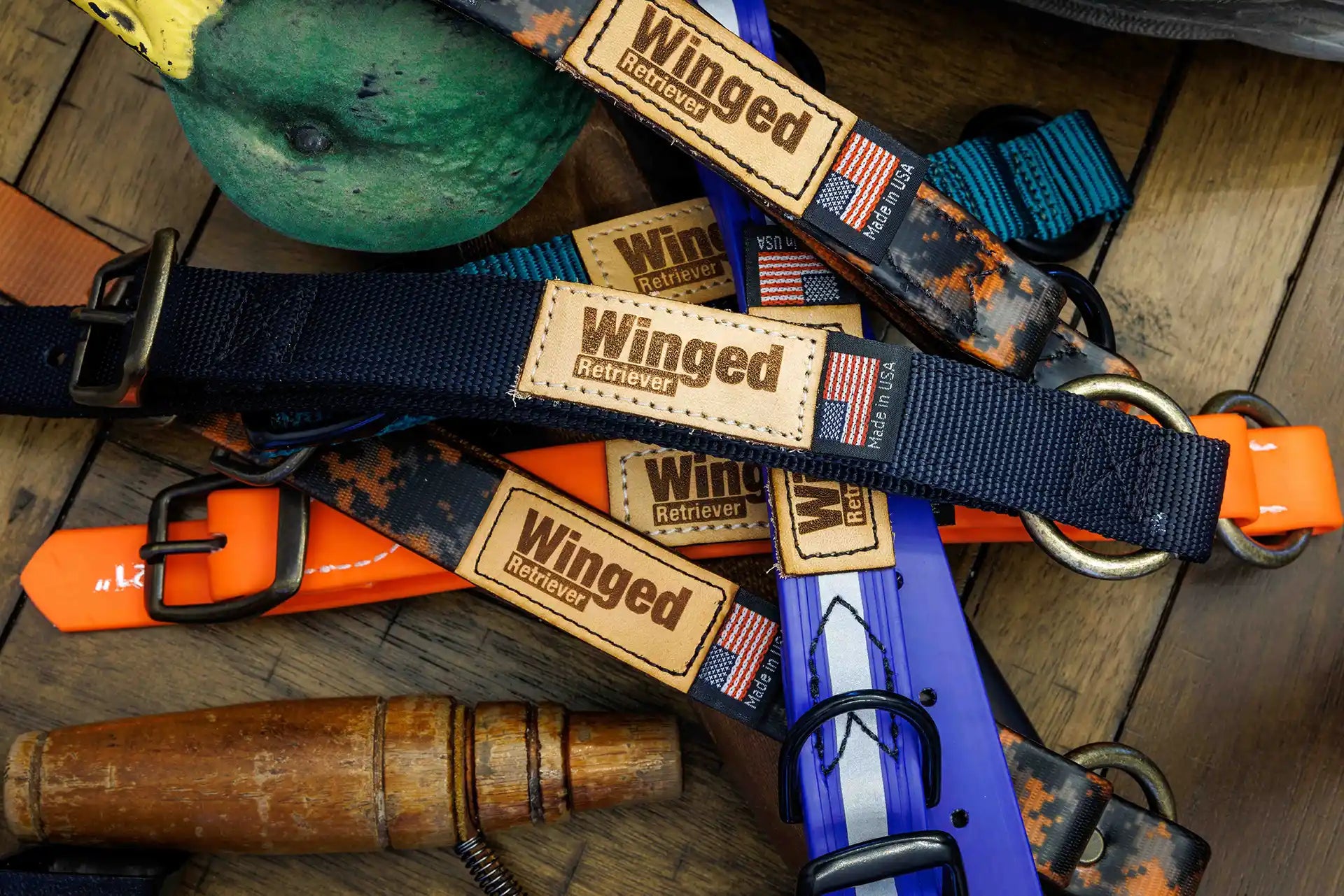 Assorted Patternmaster Wendy's Point Nylon dog collars with Winged Retriever tags on a wooden surface.